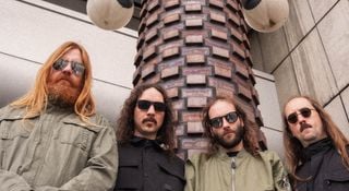 A portrait of the cosmic death metal band Blood Incantation. The Denver, Colorado quartet wear dark sunglasses.