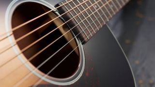 Close up of the strings on an acoustic guitar