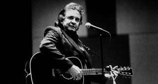 A black-and-white portrait of Johnny Cash playing a Martin acoustic