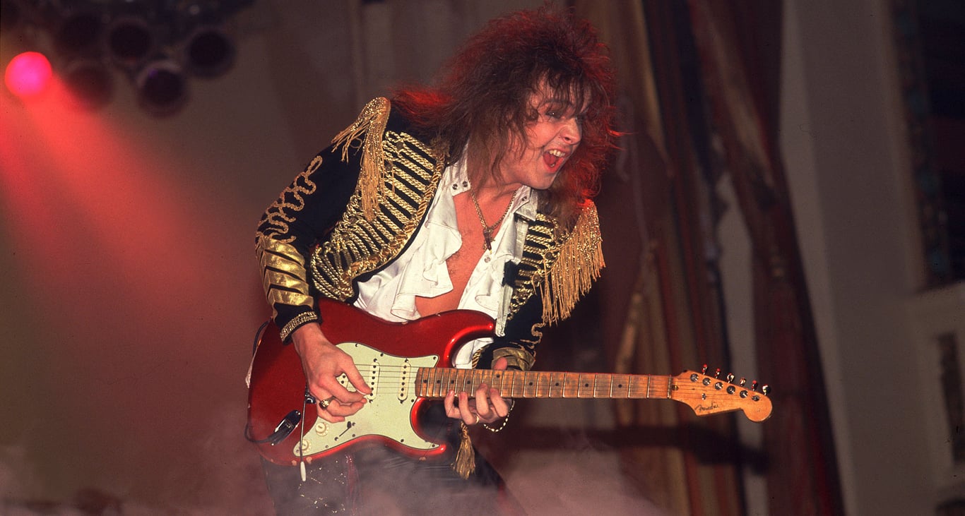 Yngwie Malmsteen in 1985, playing a Candy Apple Red Fender Stratocaster, dressed in some extravagant stagewear &ndash; even for the period.