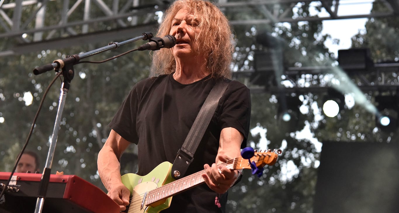 Jerry Harrison wears a black T-shirt and plays an outdoor festival show with his green Telecaster.