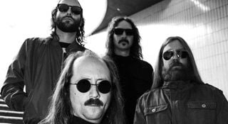 A portrait of the cosmic death metal band Blood Incantation. The Denver, Colorado quartet wear dark sunglasses.