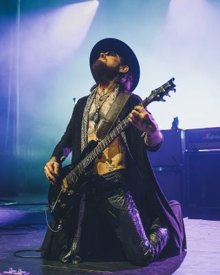 Dave Navarro on his knees, performing live with a PRS guitar