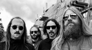 A portrait of the cosmic death metal band Blood Incantation. The Denver, Colorado quartet wear dark sunglasses.