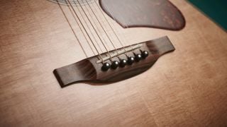 Close up of the bridge on an acoustic guitar