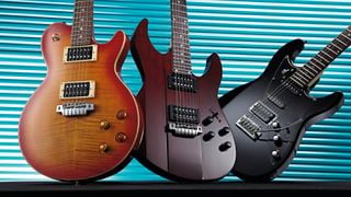 Three Line 6 JTVariax guitars &ndash;&nbsp;a JTV59, JTV89 and JTV69 &ndash; against a blue grille background