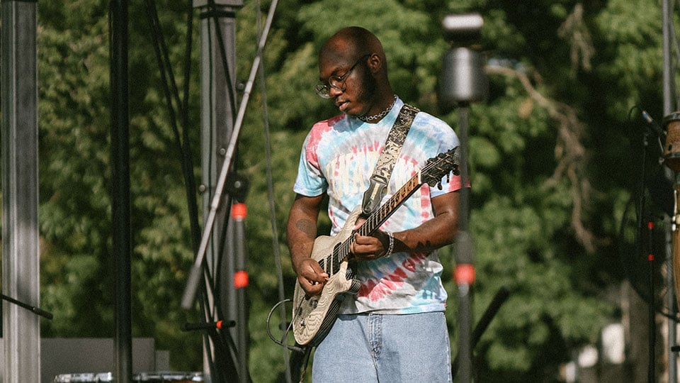 Justus West playing guitar onstage