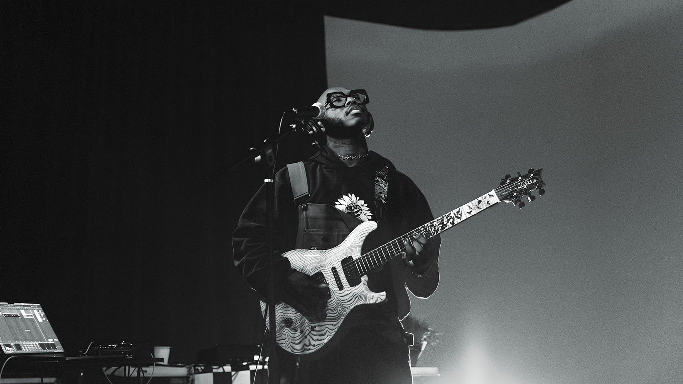 Black and white photo of Justus West playing guitar