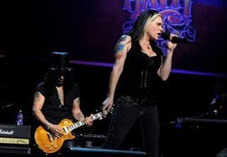 Slash (left, background) performs onstage with Beth Hart at the Nokia Theater in Los Angeles, California on February 4, 2010