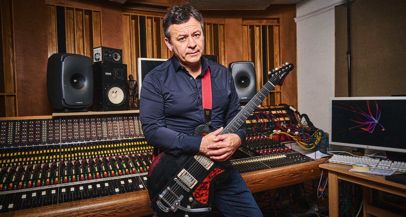James Dean Bradfield of the Manic Street Preachers pictured in the studio where he showed guitarist his Eastman and Gordon Smith guitars. He wears a dark blue shirt, studio hardware occupies the background.