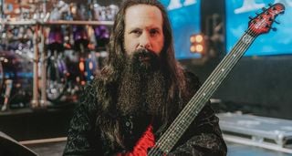 John Petrucci of Dream Theater is pictured onstage with his red signature Ernie Ball Music Man guitar