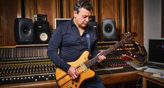 James Dean Bradfield of the Manic Street Preachers pictured in the studio where he showed guitarist his Eastman and Gordon Smith guitars. He wears a dark blue shirt, studio hardware occupies the background.