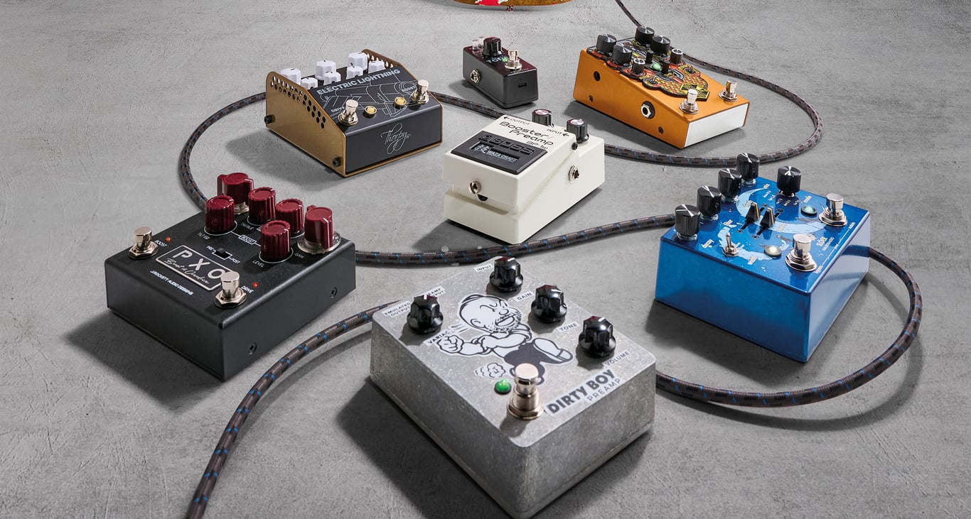 A selection of guitar pedals are photographed against a concrete floor.