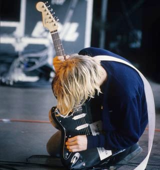 Kurt Cobain leans over his guitar onstage at the Pukkelpop Festival in Hasselt, Belgium on August 25, 1991