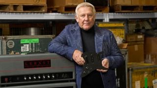 Alex Lifeson poses next to a Lerxst guitar amp