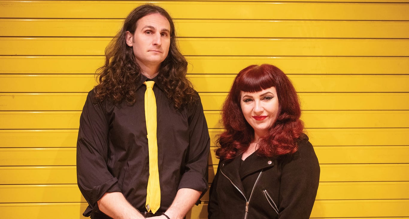 Dan Mancini and Christina Inman of Third Man Hardware photographed against a yellow wall. Mancini wears Third Man team colors: black shirt, yellow tie.