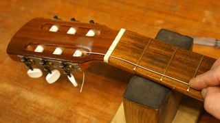 Feeding a classical guitar string through the string post