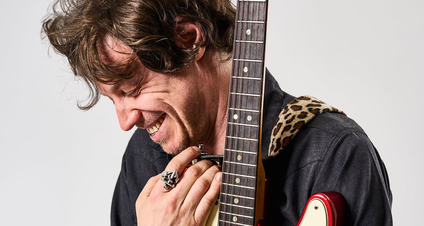 James Walbourne smiles as he holds his red Telecaster close.