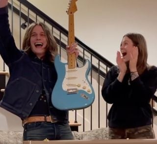 Tyler Bryant holds the Strat aloft while Rebecca Lovell applauds