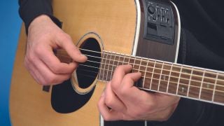 A man plays fingerstyle acoustic guitar