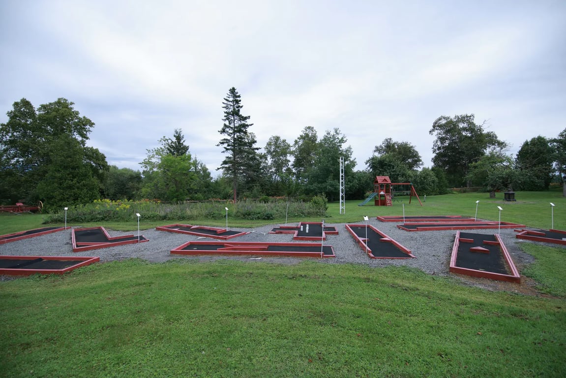 Parcours de mini-golf extérieur bordé de rouge sur le terrain de l’hôtel