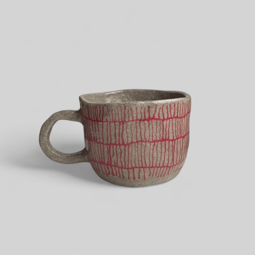 Pinchet kop med hank i mørk stentøjsler. Indeholder cirka 230  ml. 