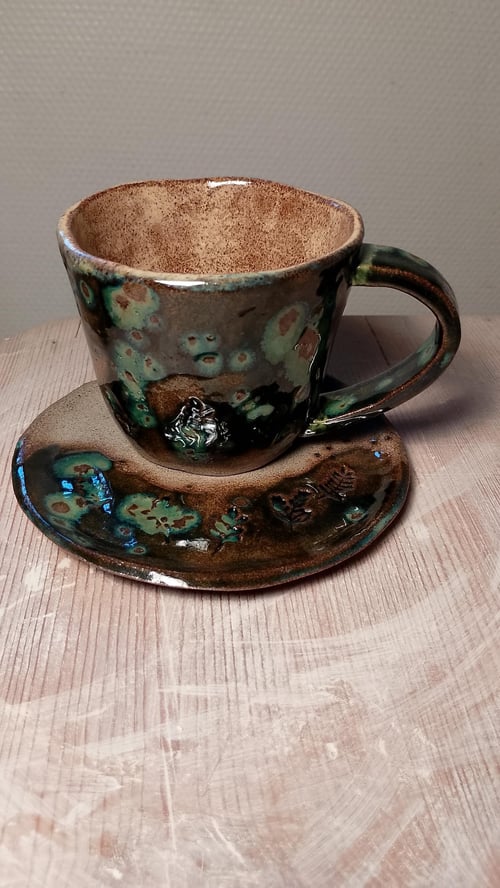 Håndlavet kop og underkop i stentøj, koppens højde er 8 cm. 