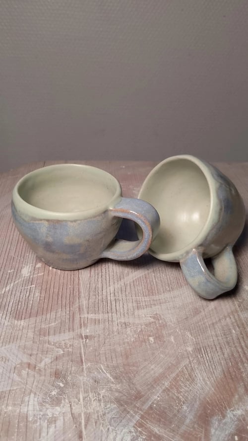 Håndlavet kaffekop i stentøj. Lys blå og lys grøn glasering. Højde 6 cm. Prisen er pr. stk.