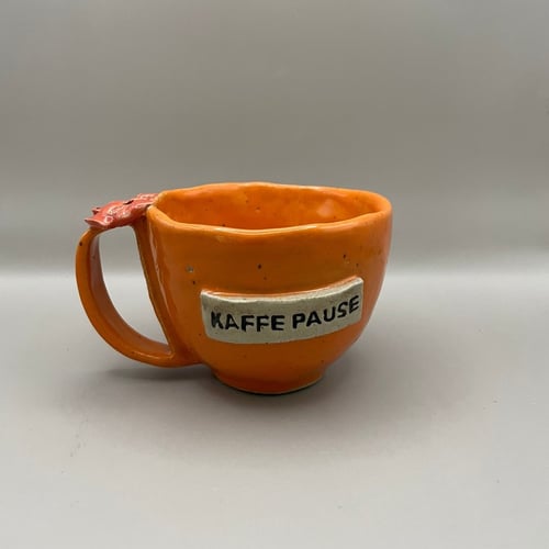 Kop med tekst “kaffepause” orange med rød sløjfe