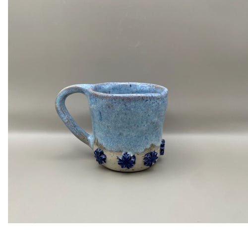 Lyseblå kop med mørkeblå blomster