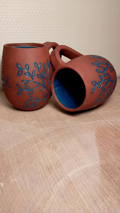 Håndlavet kaffe/tekrus med udskæringer i stentøj, højde 10 cm. Prisen er pr. stk.