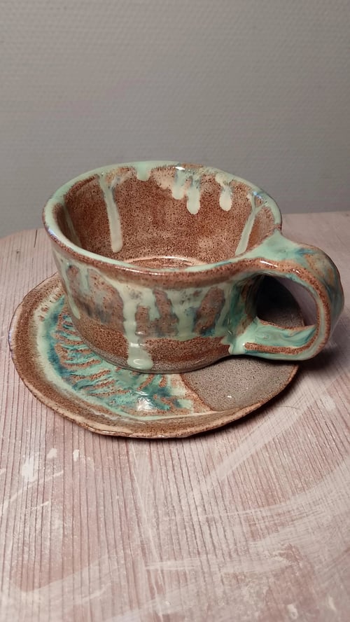 Håndlavet kop og underkop i stentøj, koppens højde er 6 cm.