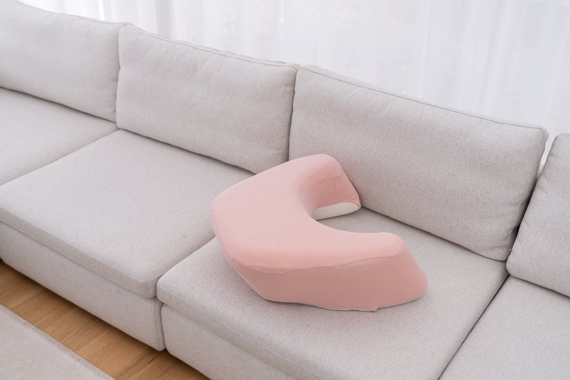 明るいリビングのソファに置かれたピンク色のレベルアップクッション