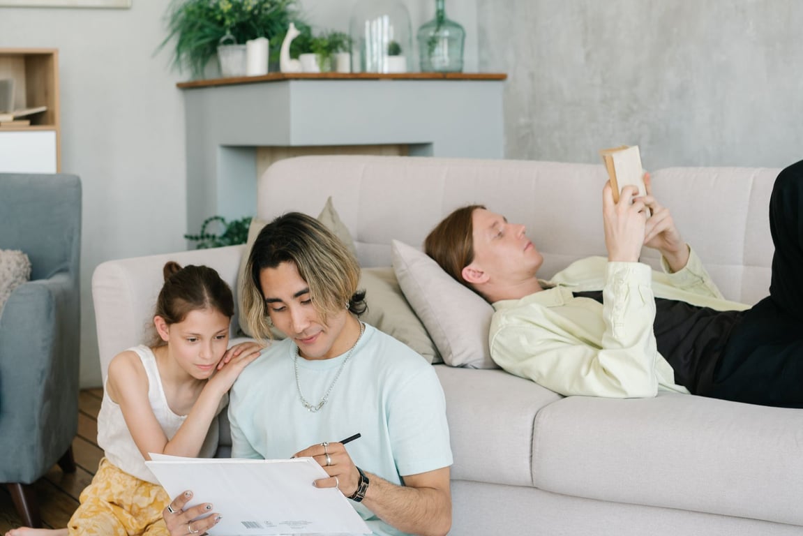 A family spending quality time together on a sofa in a modern living room, reading and connecting in a comfortable home setting