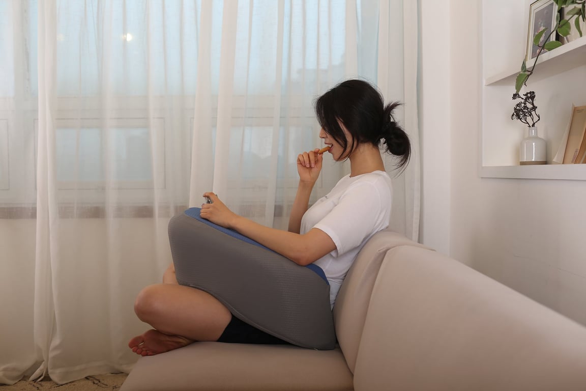레벨업쿠션을 무릎 위에 올려 팔꿈치를 받치며 스마트폰을 조작하는 모습