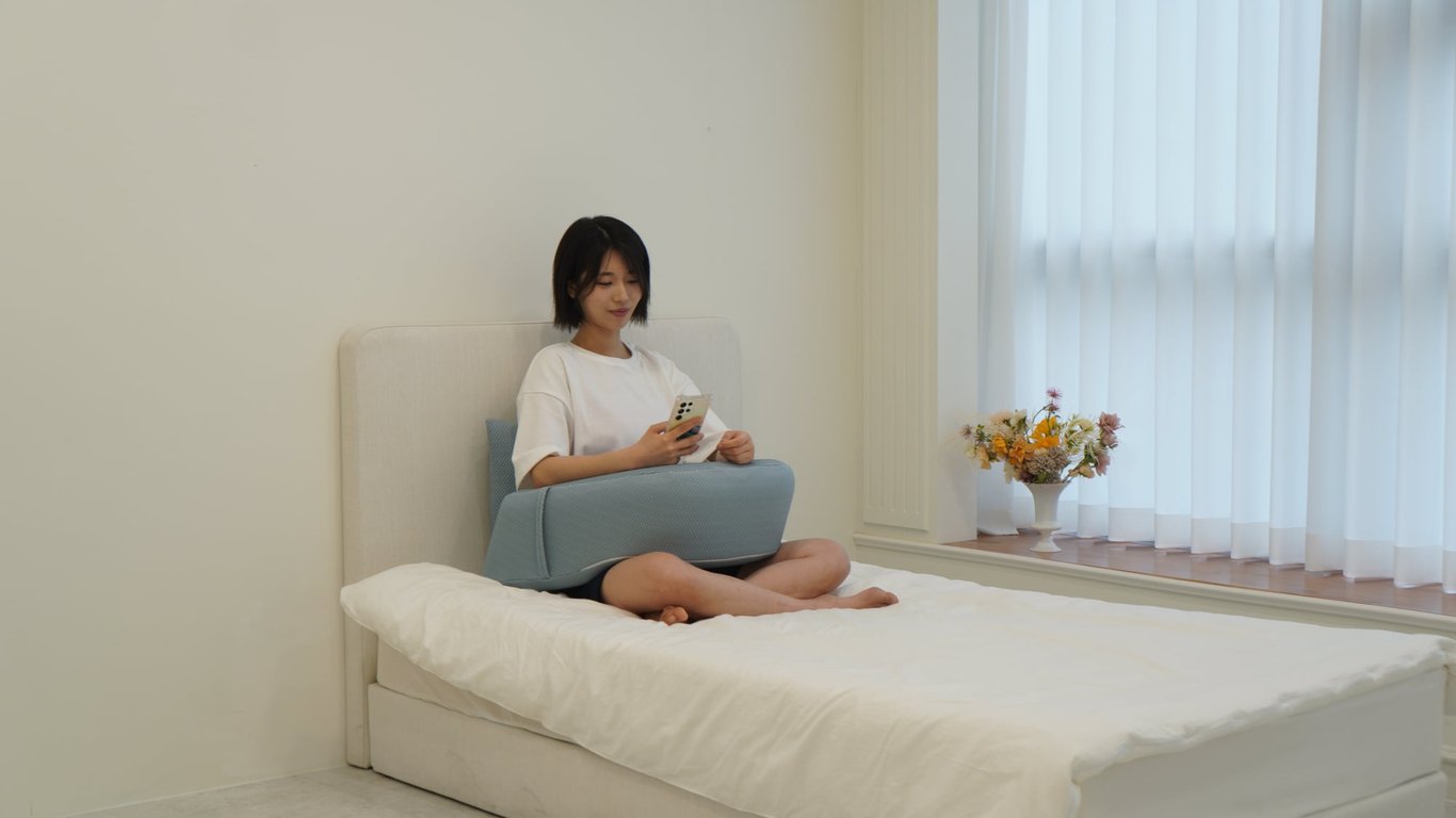 휴식을 취하며 스마트폰을 볼 때 팔과 무릎 아래에 쿠션을 넣어 편안한 자세를 유지하는 모습