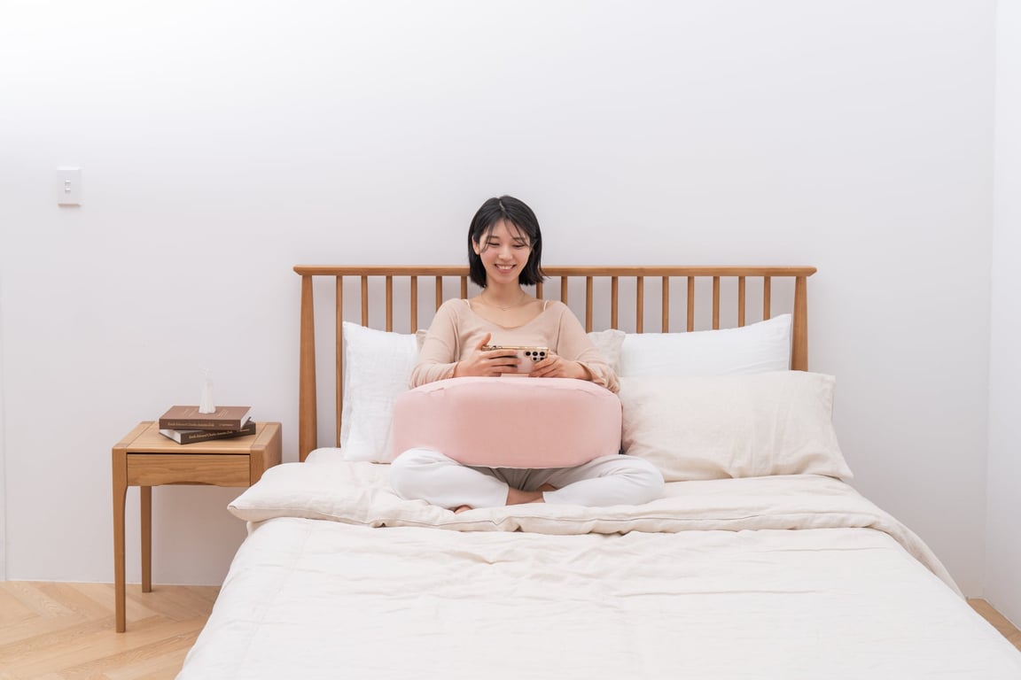 ソファで作業する際、レベルアップクッションの上に肘を乗せて快適な姿勢を保つ様子