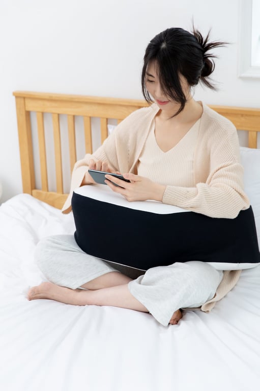 床に座りスマホを使用する女性と、膝下に置かれたレベルアップクッション