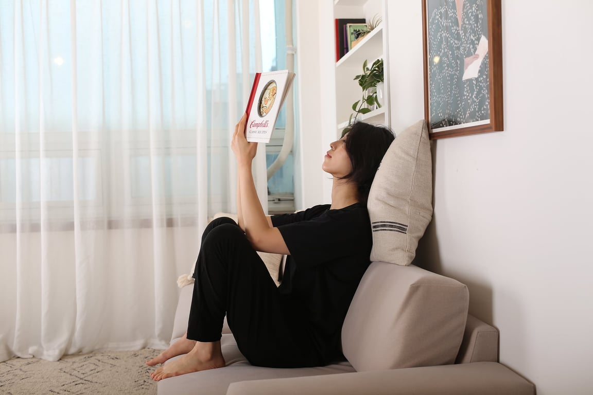 베이지색 레벨업쿠션을 등 뒤에 대고 편안하게 책을 읽는 여성