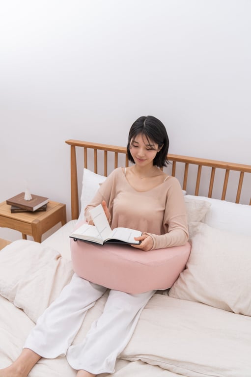 ベッドで本を読みながらリラックスしている女性の腕とレベルアップクッション