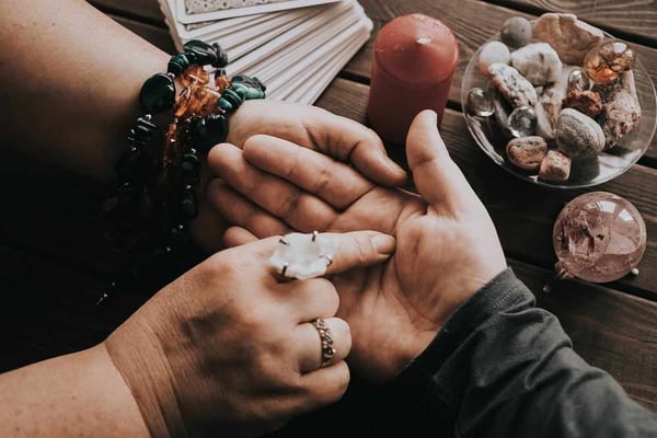 Lectura de la mano junto a una vela y piedras naturales