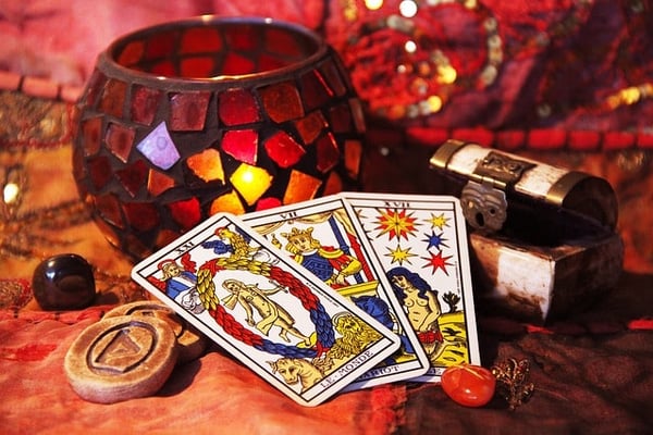 Cartas del tarot junto a un portavelas de mosaico encendido