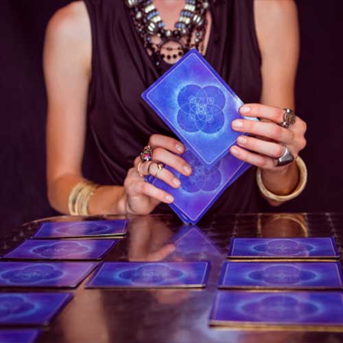Manos sosteniendo cartas del tarot sobre la mesa