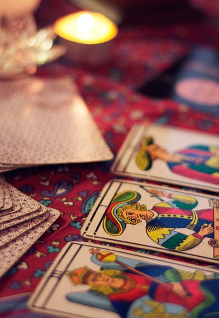 Cartas del tarot de Marsella sobre un mantel rojo con una vela