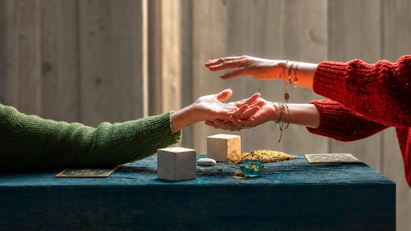 Manos sobre la mesa durante una consulta de tarot telefónico fiable