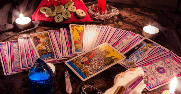Buenas videntes por teléfono: cartas en abanico con runas y una vela roja