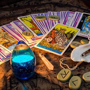 Cartas del tarot con vela azul y runas