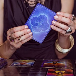 Manos con anillos sosteniendo una carta azul
