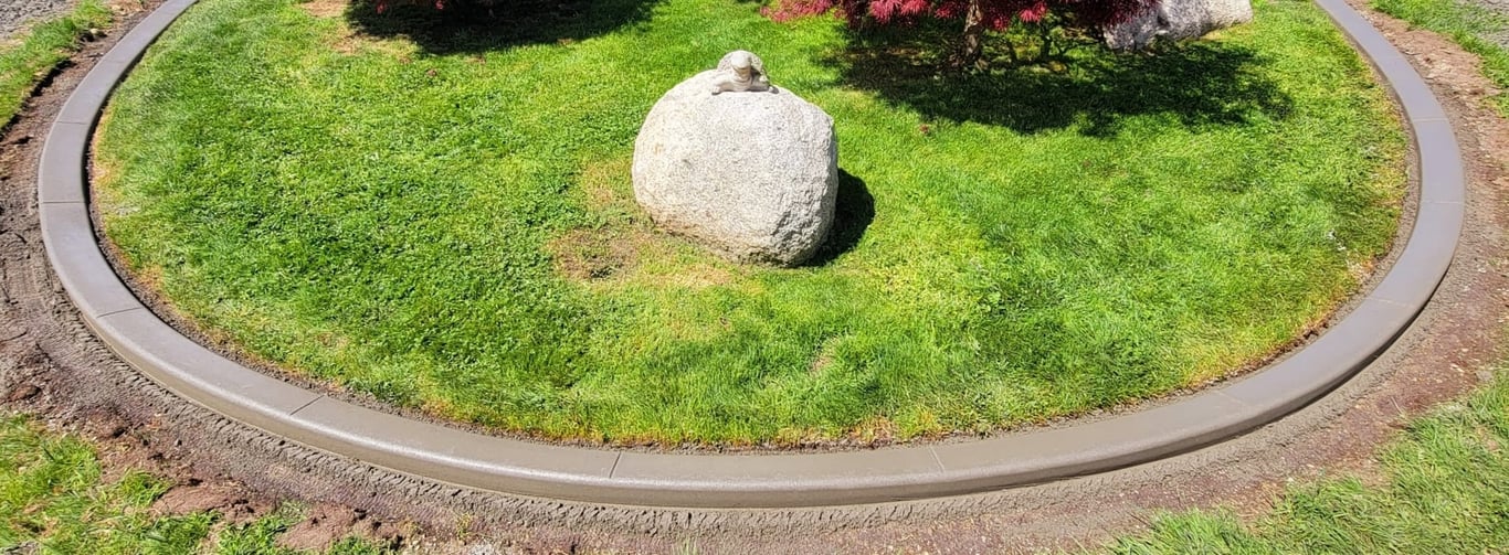 Fresh curbing surrounding some decorative rocks and trees