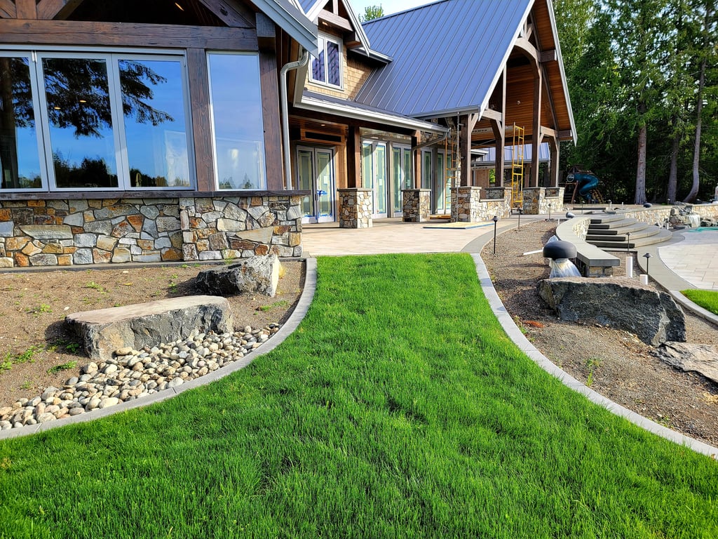 Curbing framing a grass walkway up to a nice house